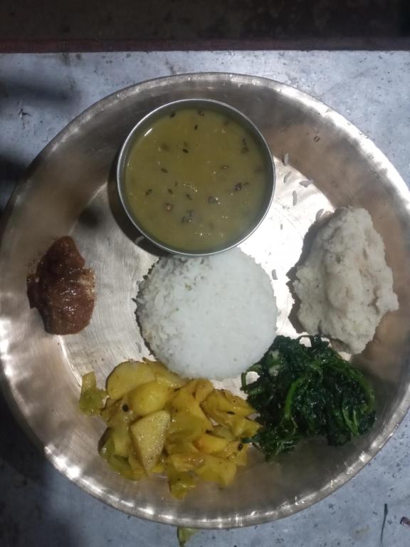 a plate of food with rice and a bowl of soup at Unique point home stay in Nagarkot