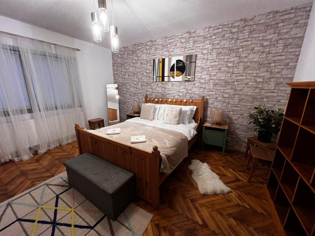 a bedroom with a bed and a brick wall at Eden Garden in Braşov