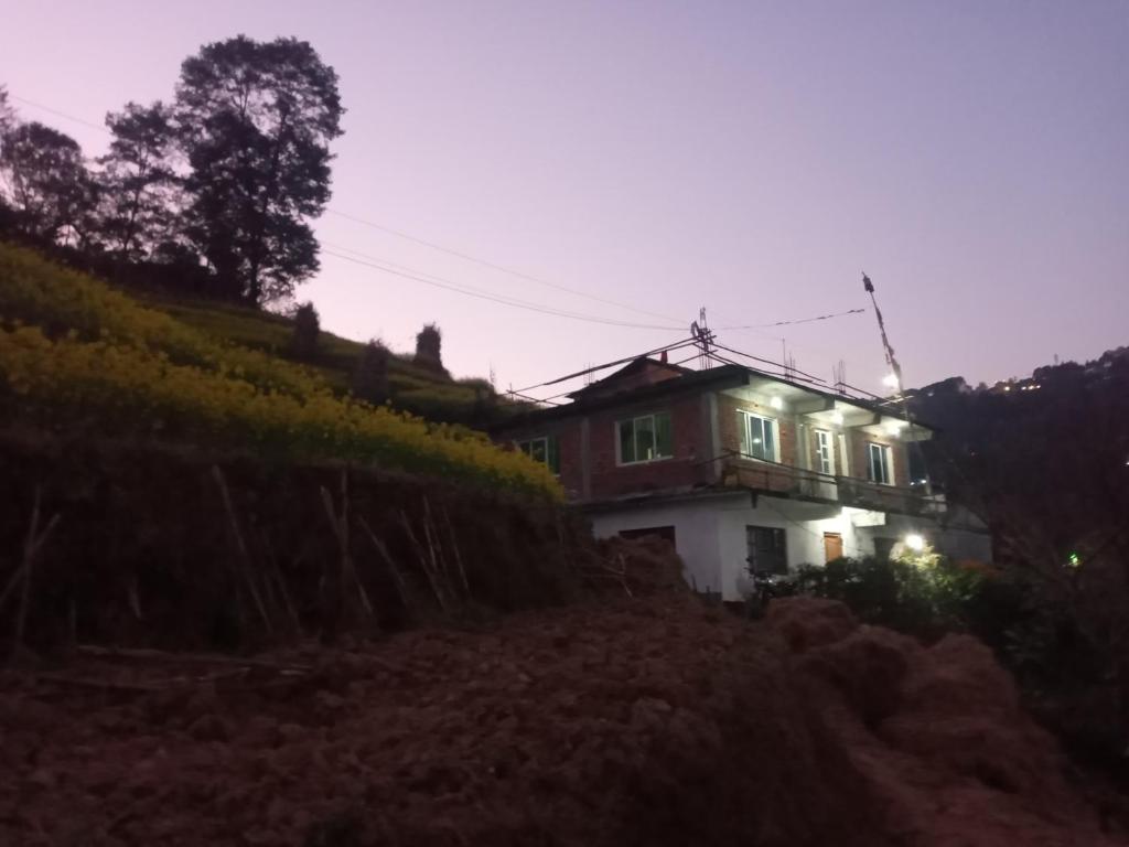 a house on the side of a hill at night at Unique point home stay in Nagarkot