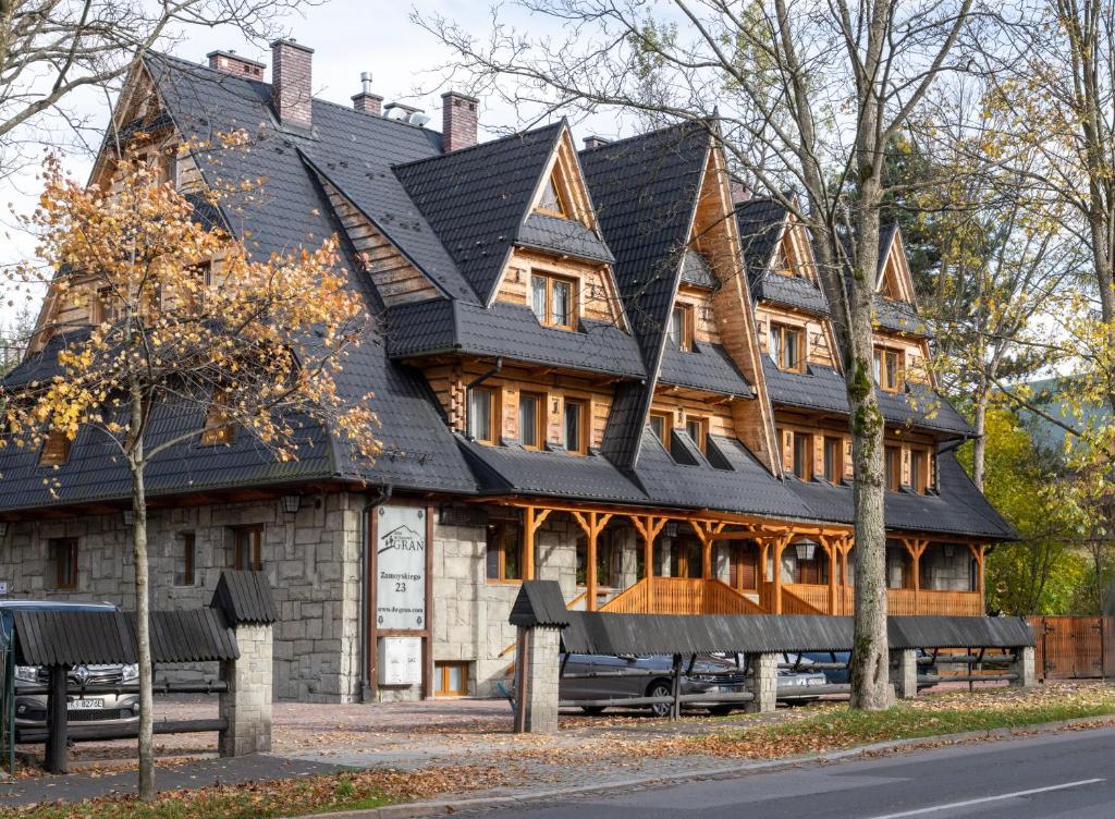 a large wooden house with a black roof at Dom Wczasowy Grań in Zakopane
