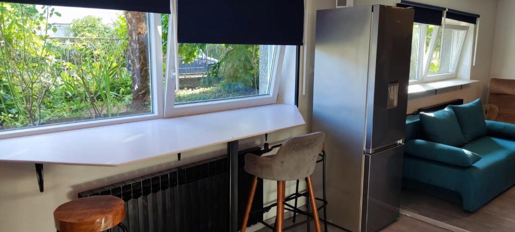 een keuken met een aanrecht, een koelkast en een stoel bij Apartman Maksimir Rebro Jordanovac Luka in Zagreb