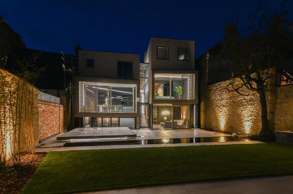 a house with a lawn in front of it at night at Contemporary home in historic town in Woodstock