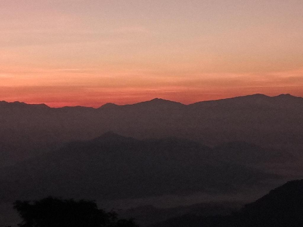 a view of a mountain range at sunset at Unique point home stay in Nagarkot