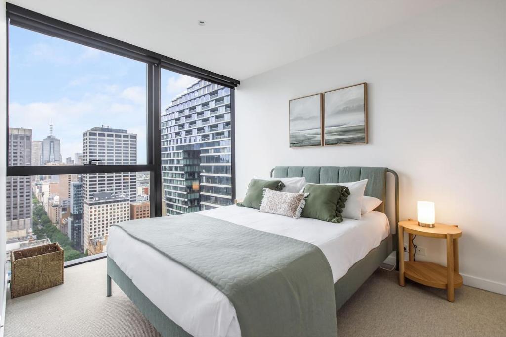 sypialnia z łóżkiem i dużym oknem w obiekcie Posh Perch on Collins - A Cosy Couple's Haven w Melbourne