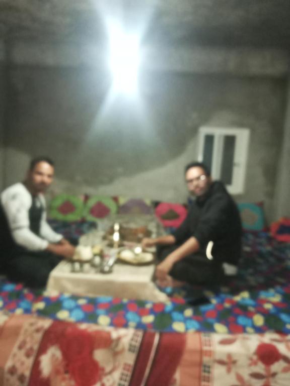 two men sitting on the floor in a room at Unique point home stay in Nagarkot
