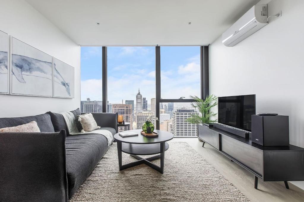 sala de estar con sofá y TV en Aloft on Collins - Skyline Views from the 53rd Floor en Melbourne