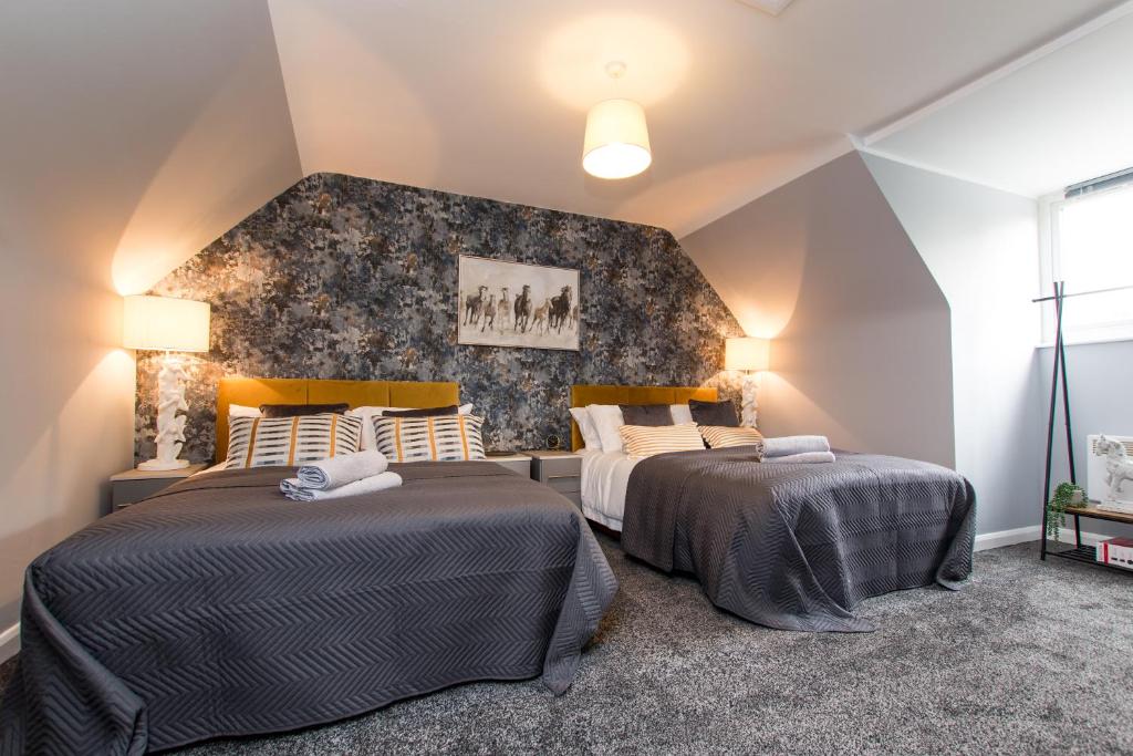 - 2 lits dans une chambre avec un mur dans l'établissement Newly Renovated Modern House with FREE Parking, à Nottingham