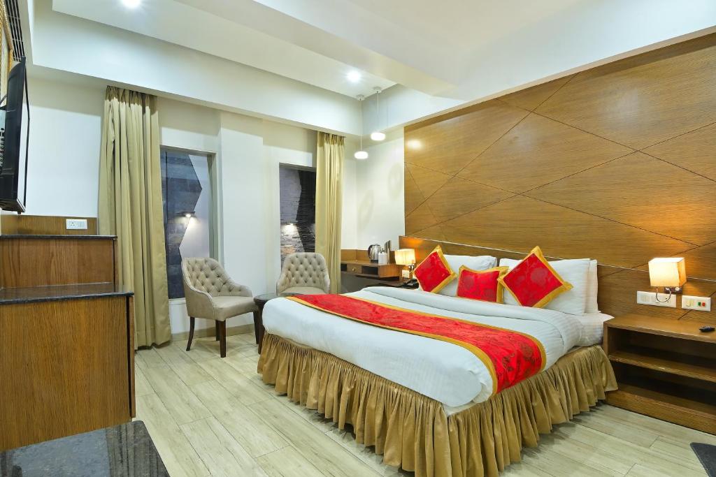 a hotel room with a large bed with red pillows at Hotel Hari Piorko - New Delhi Railway Station in New Delhi