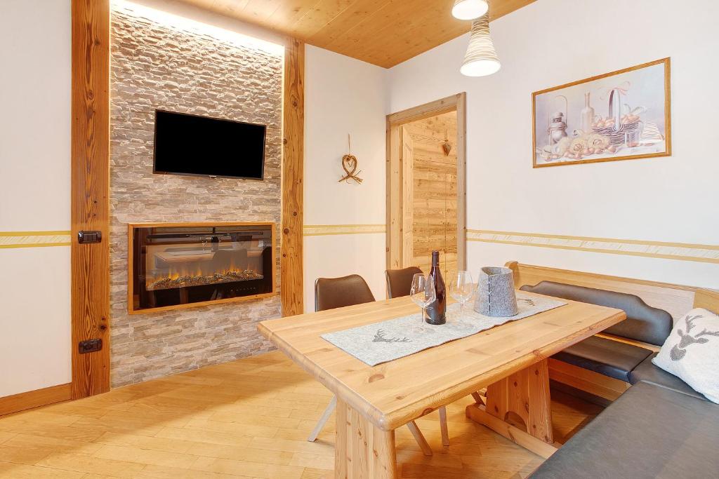 een woonkamer met een tafel en een open haard bij Iride Villa Nordica in Livigno
