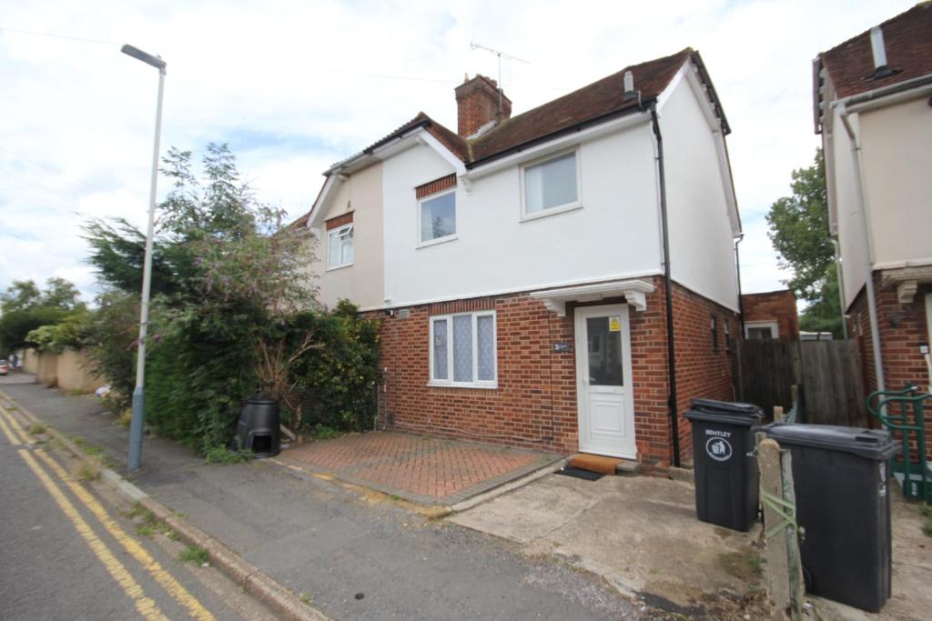 a white and red brick house on a street at Rockingham House Uxbridge in Uxbridge