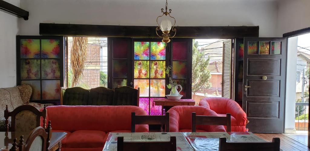 a living room with red chairs and stained glass windows at Malala Jujuy Hostel in San Salvador de Jujuy