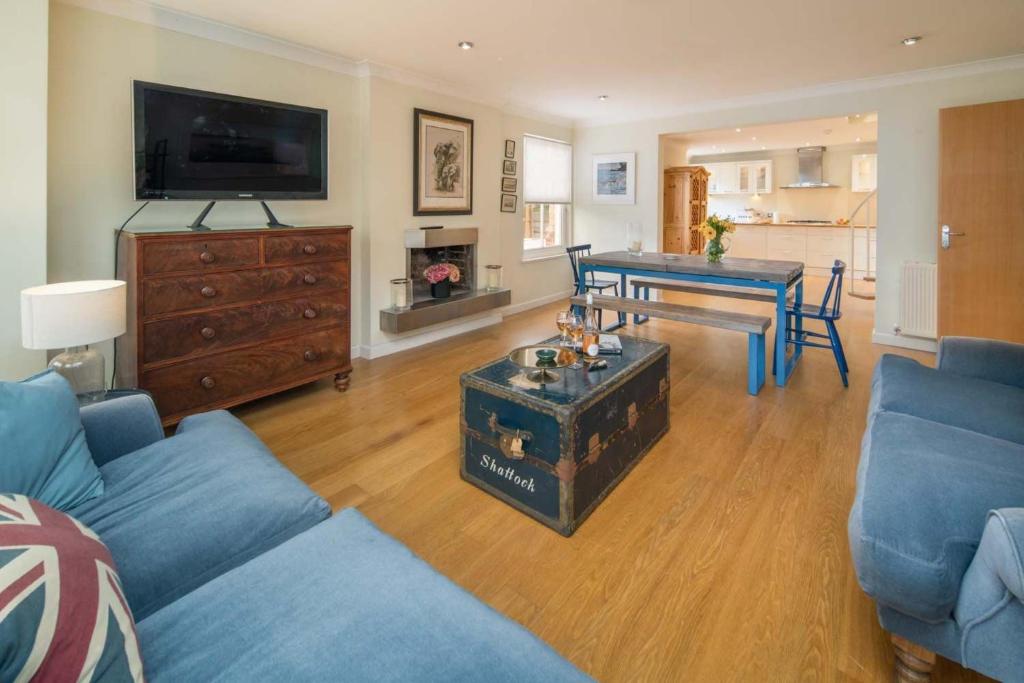 a living room with a blue couch and a table at Flat 1, Medeira House in Seaview