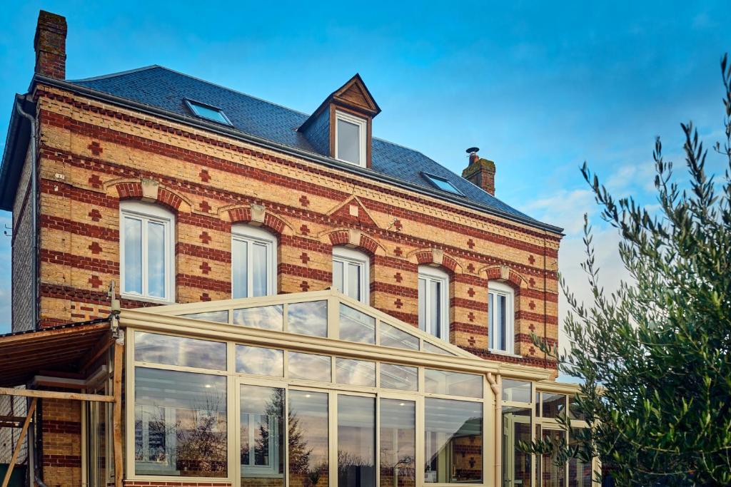 Le Vaudreuil的住宿－LE CLOS 1899，一座大型砖砌建筑,前面设有温室