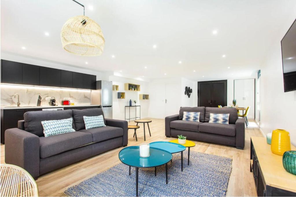 a living room with two couches and a table at Résidence Villette - Buttes Chaumont Botzaris in Paris