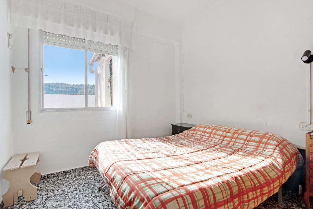 a white bedroom with a bed and a window at Atico con doble terraza Jerica in Jérica