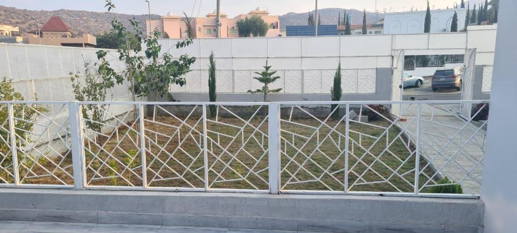 a white fence in front of a parking lot at شالية ألأمراء 