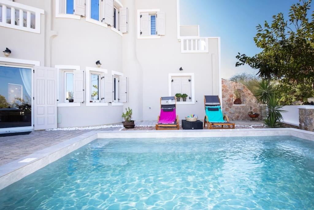 a house with a swimming pool and two chairs at Selenophile Villa in Monolithos