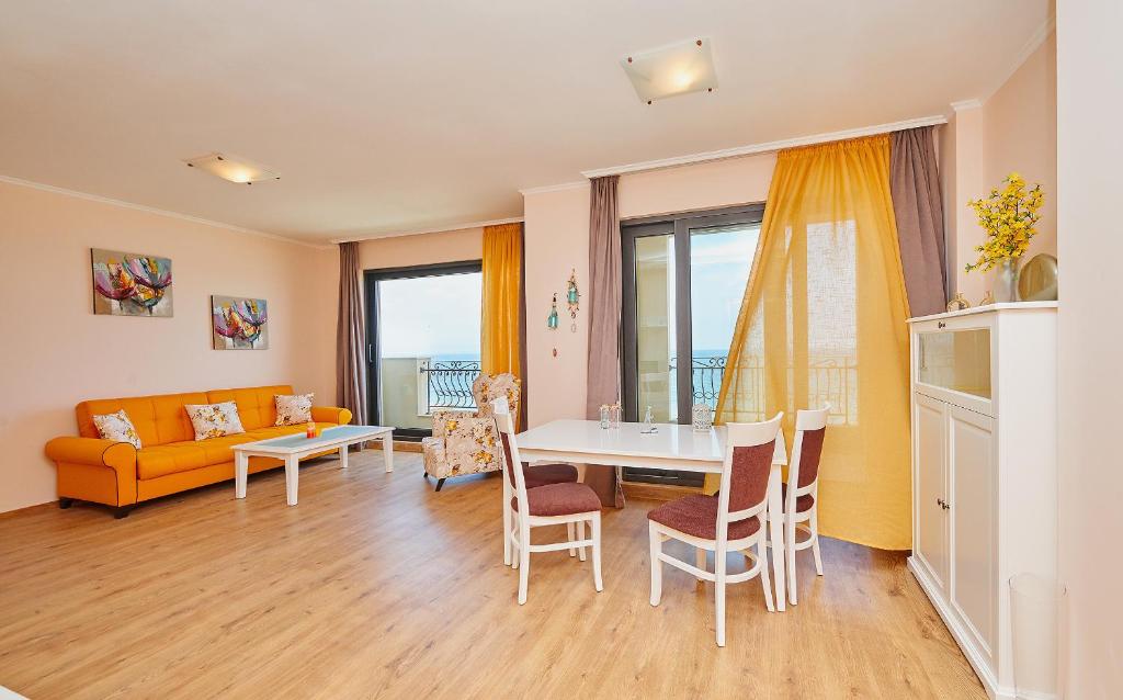 een woonkamer met een tafel en een bank bij Pomorie Seafront Apartments in Pomorie