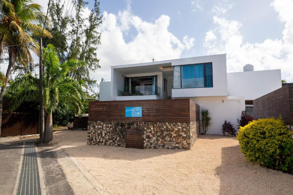 una casa en una playa con una pared de piedra en Villa Ocean Vista by Swarga Mauritius en Pereybere