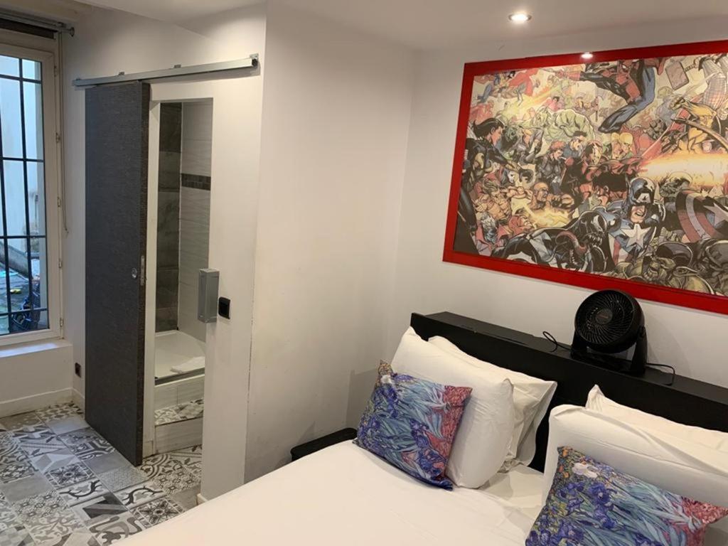 a bedroom with a painting on the wall and a bed at 15 Atelier Montorgueil Super Héros in Paris