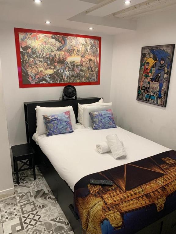 a bed in a room with a painting on the wall at 15 Atelier Montorgueil Super Héros in Paris