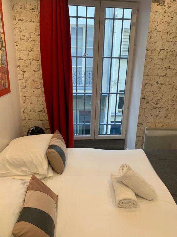 a bed with two towels on it with a window at 15 Atelier Montorgueil Super Héros in Paris