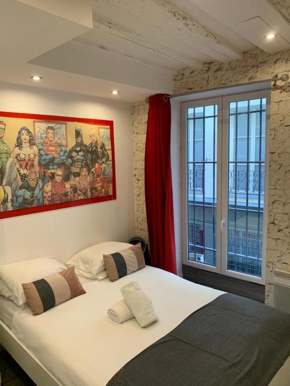 a bedroom with a large bed with a painting on the wall at 15 Atelier Montorgueil Super Héros in Paris