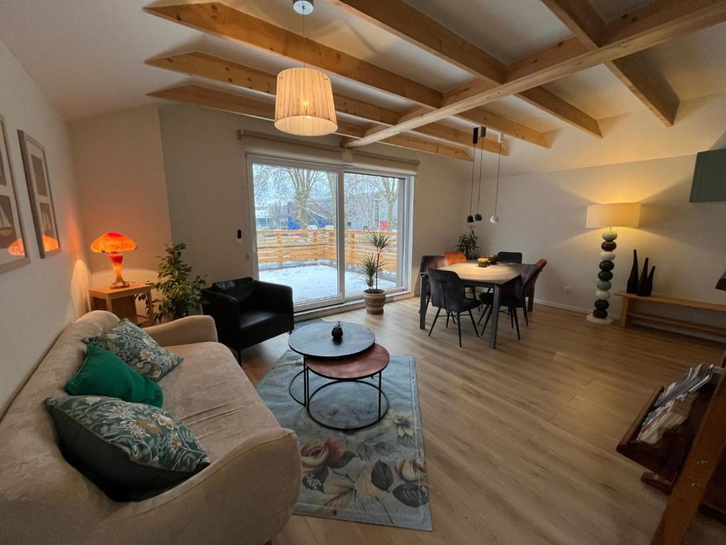 sala de estar con sofá y mesa en Gîte'appart "des cîmes et jardin", en Illkirch-Graffenstaden