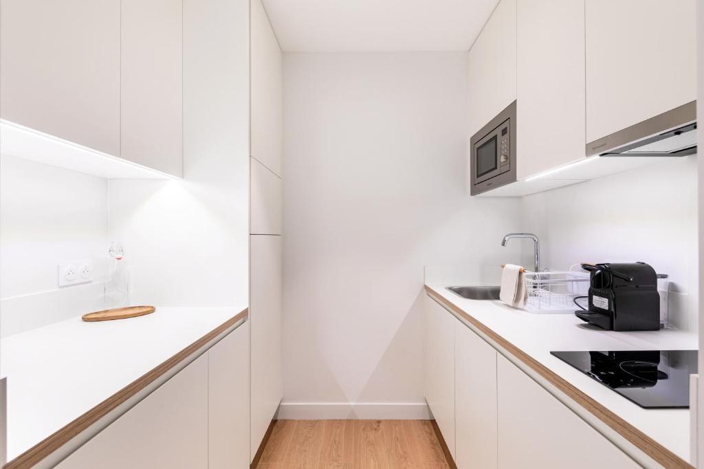 a kitchen with white cabinets and a counter top at Les Appartements de Grenoble in Grenoble