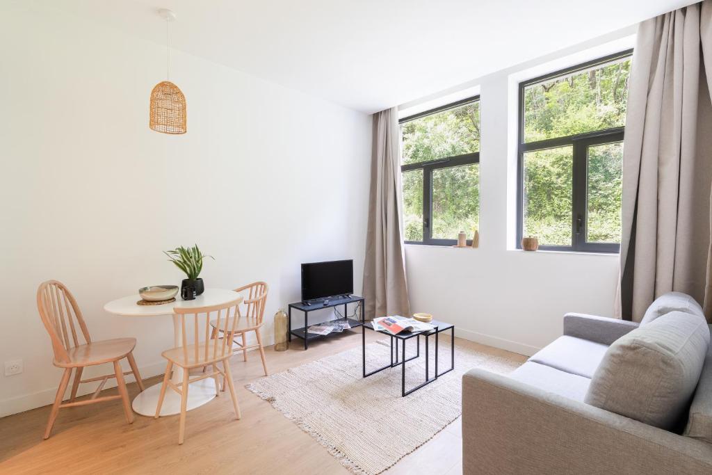 a living room with a couch and a table at Les Appartements de Grenoble in Grenoble