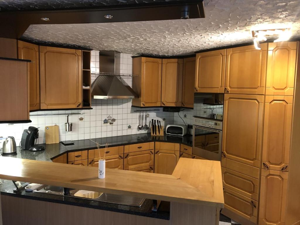 een keuken met houten kasten en een houten aanrecht bij NEU! Ferienwohnung Kippblick Schiffweiler in Schiffweiler