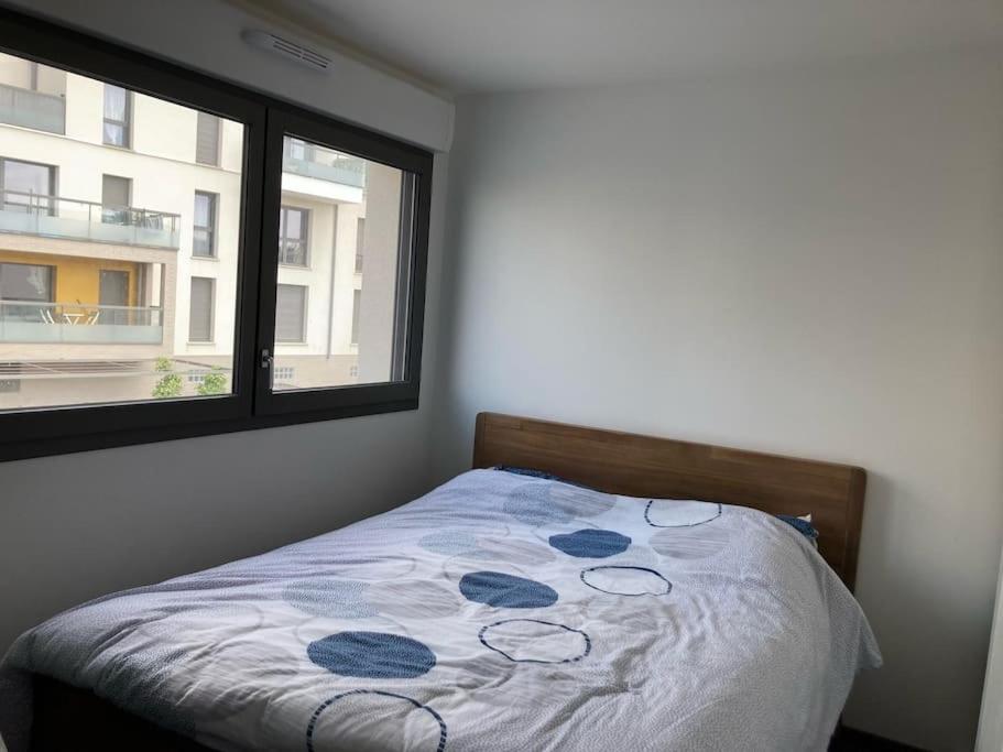 a bed in a bedroom with a window at Maison proche de Versailles JO2024 in Saint-Cyr-lʼÉcole