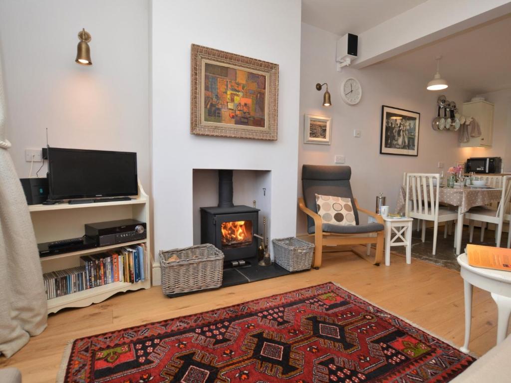 a living room with a fireplace and a tv at 3 Bed in Bothenhampton DC160 in Bridport
