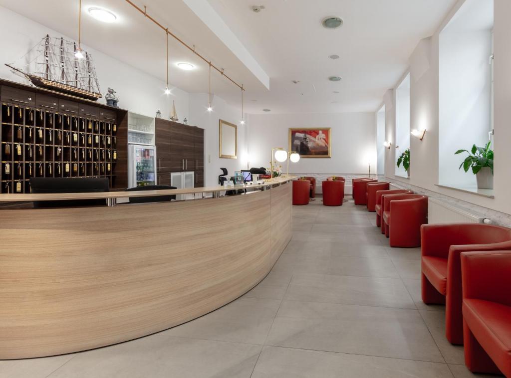 een lobby met rode stoelen en een wijnbar bij Hotel Admiral in Wenen