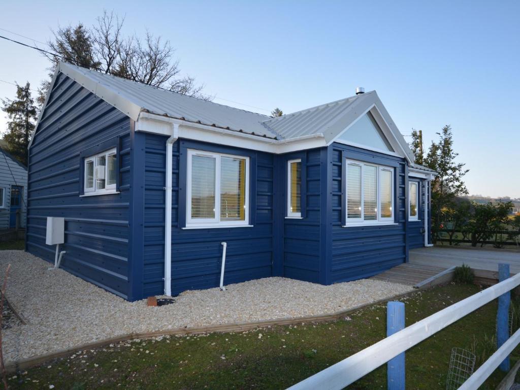 a blue tiny house sitting on top of a driveway at 2 bed in Llansteffan 74268 in Ferryside