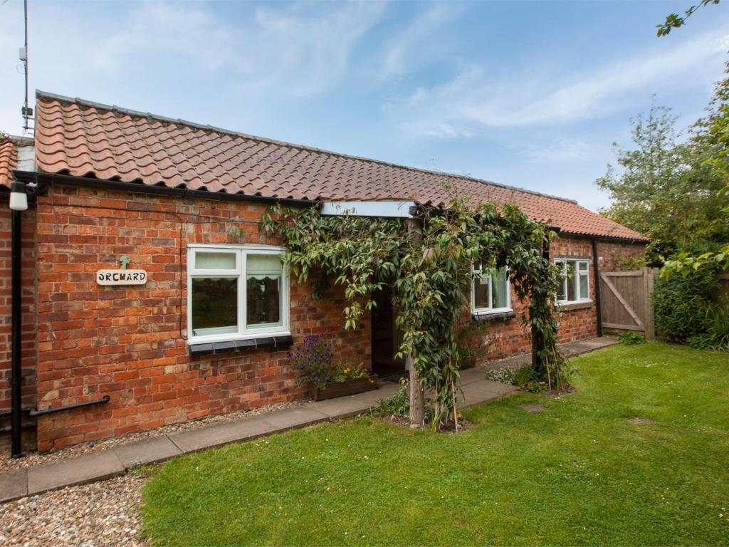 a red brick house with a green yard at 2 Bed in Howden G0104 in Saltmarshe