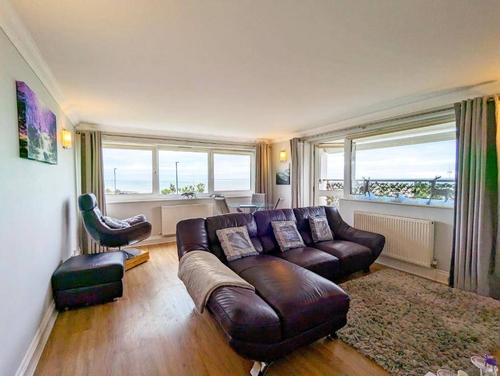 a living room with a leather couch and a chair at The Gables in Bognor Regis