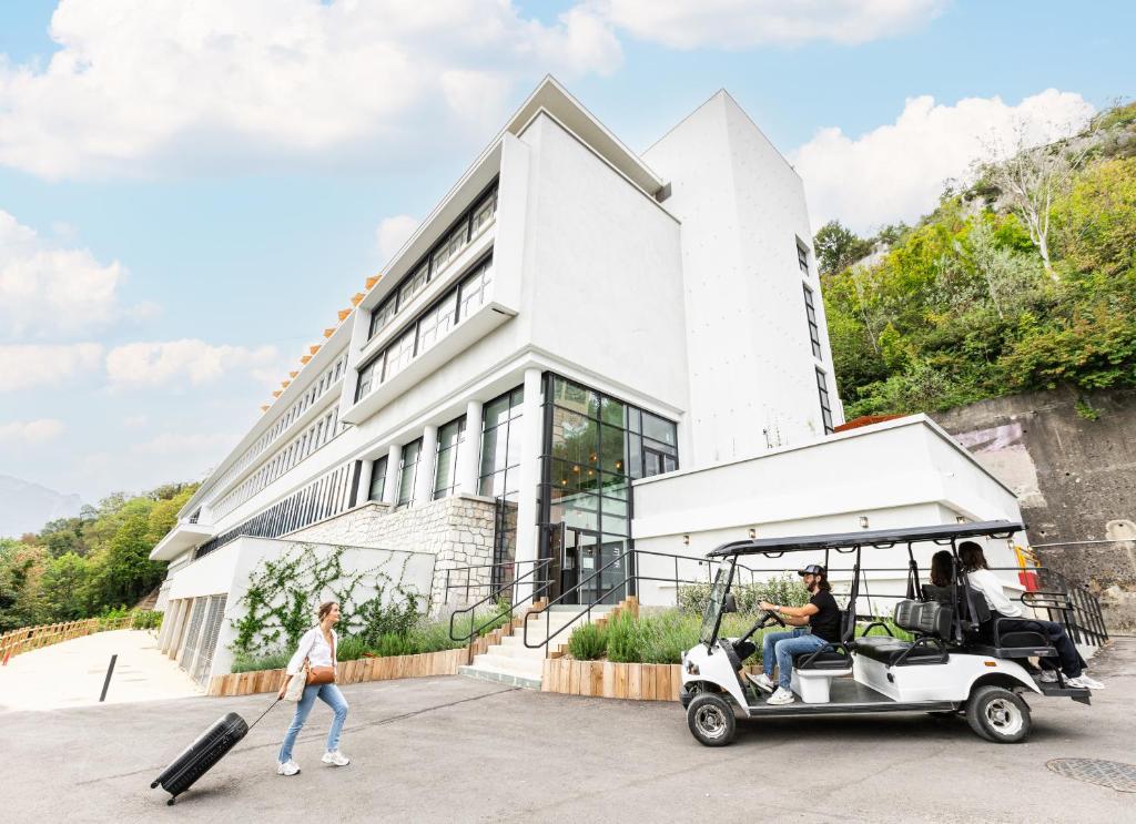 a man in a golf cart in front of a building at Les Appartements de Grenoble in Grenoble