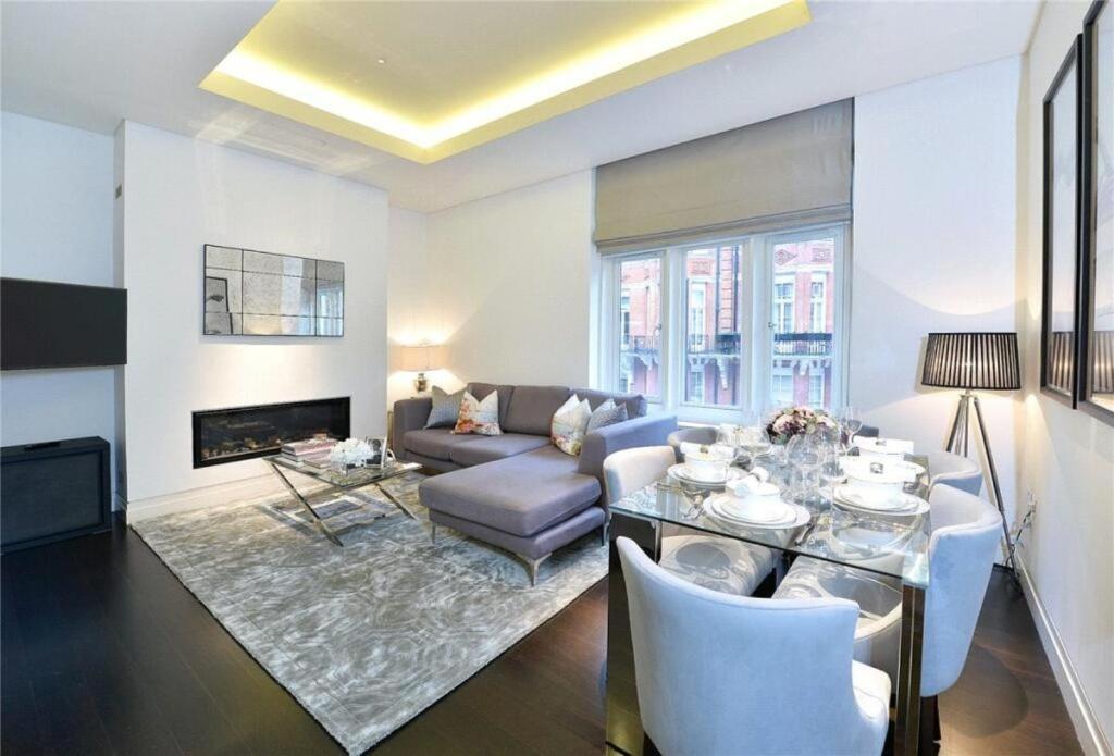 a living room with a couch and a table at PARK LANE LARGE LUXURY SLEEPS 6 in London