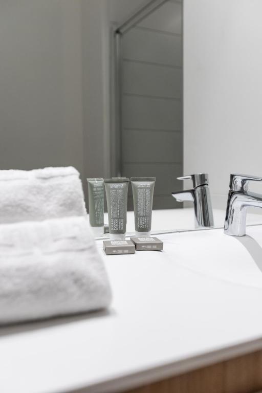 a bathroom counter with two cups and a sink at Les Appartements de Grenoble in Grenoble