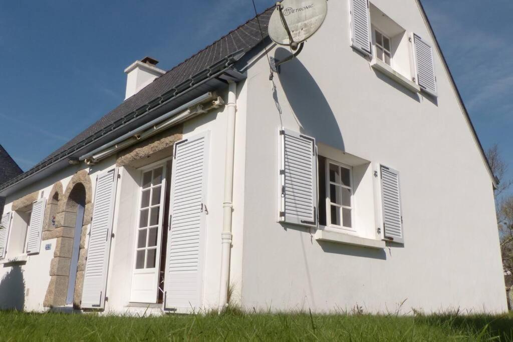 a white building with shuttered windows at Ravissante maison traditionnelle bretonne, proche Ria d'Etel in Belz