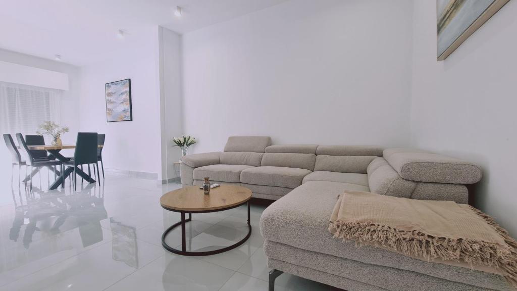 een woonkamer met een bank en een tafel bij STAY Elysian House in Limassol