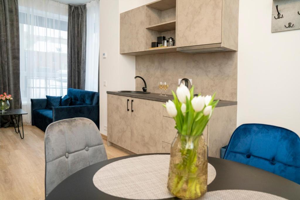 una cocina y una sala de estar con una mesa con flores. en Central Station Apartment No4, en Kaunas