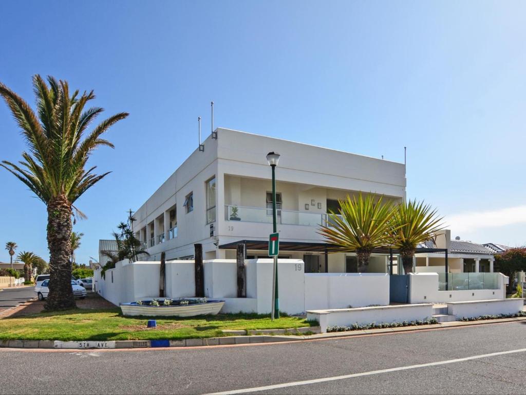 a white building with palm trees in front of it at 19 Beach Road in Cape Town
