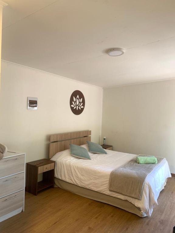 1 dormitorio con 1 cama y reloj en la pared en Cabaña Ensenada, Puerto Varas - 1 ambiente en Puerto Varas