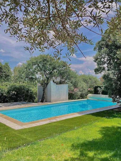 une piscine au milieu d'une cour dans l'établissement Villa de charme avec piscine 5 min d'Avignon, aux Angles (Gard)