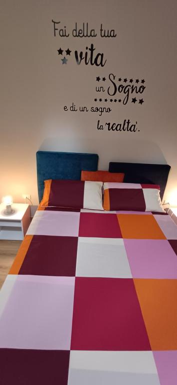 een slaapkamer met een bed en een geruite vloer bij Pollino guest house in Castrovillari