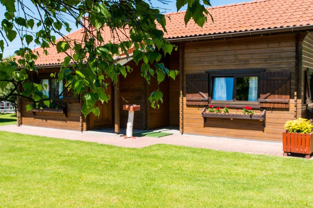 ein Holzhaus mit zwei Fenstern mit Blumen drauf in der Unterkunft Noclegi-Dobczyce in Dobczyce