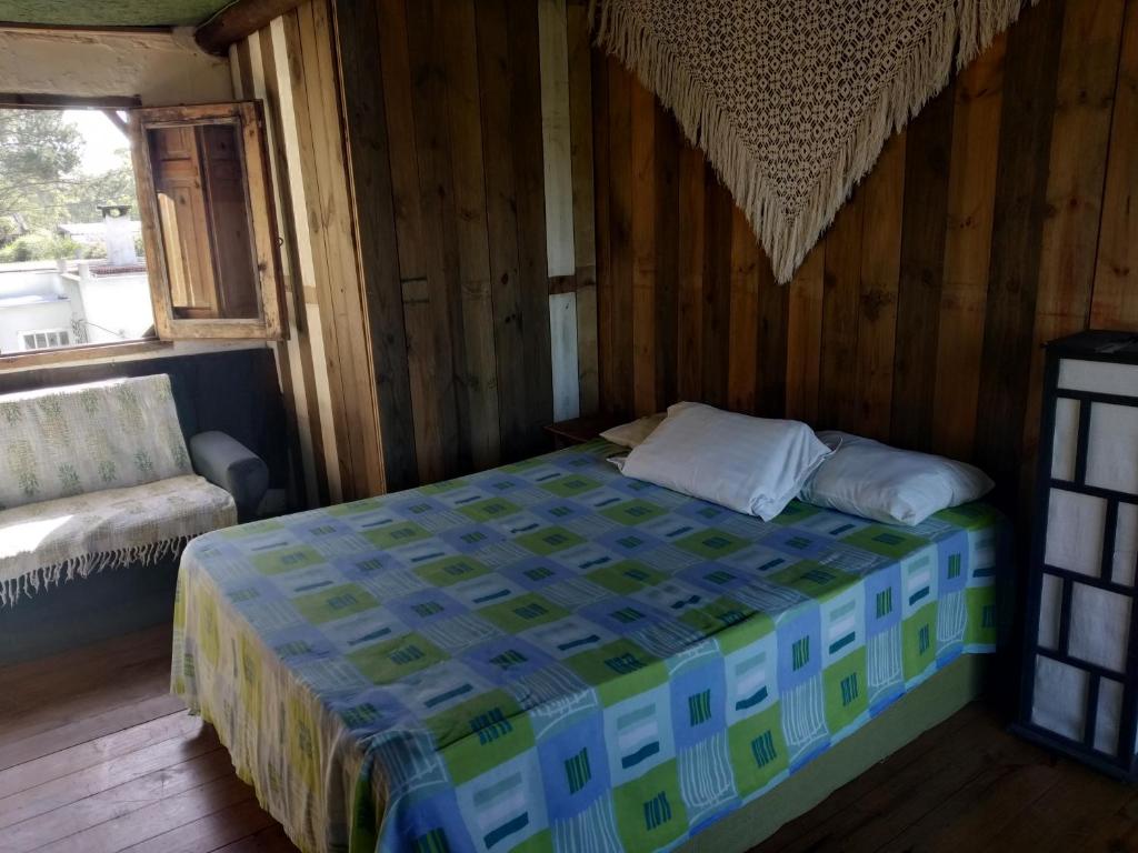 1 dormitorio con 1 cama en una habitación de madera en Para pasar bien!, en Maldonado