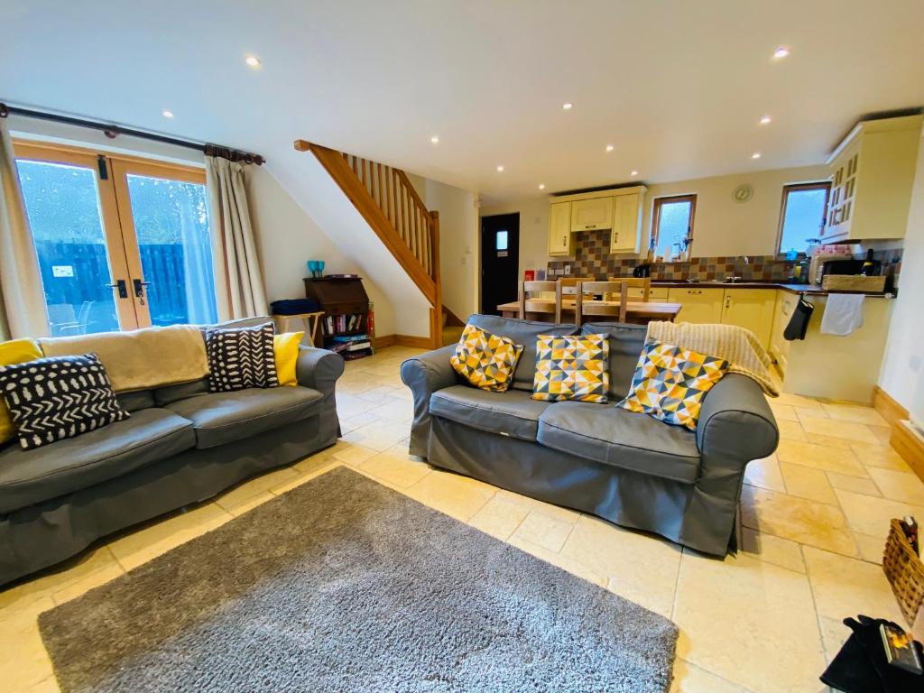 a large living room with couches and a kitchen at Clara Cottage in Eyam